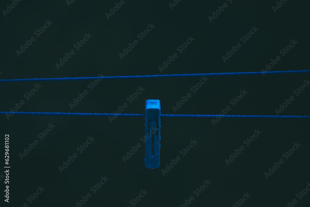 a clothespin hangs on a wire a clothespin hangs on a wire