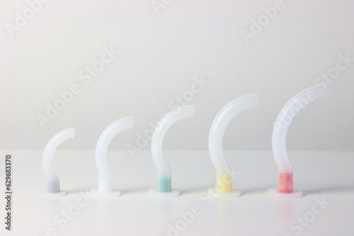 Oropharyngeal airway cannula in a white surface aligned by the size of each cannula. Small to big size. 0 to 5 size of a guedel cannula 