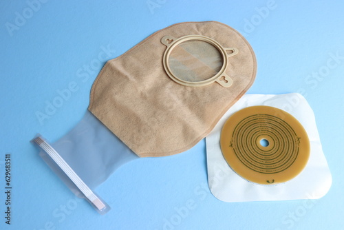 Colostomy bag in a light blue background. Bag and adhesive in a surface  photo