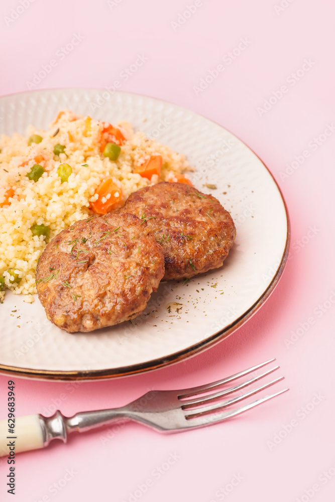 Cutlets with bulgur, boiled vegetables and fork on pink background Cutlets with bulgur, boiled vegetables and fork on pink background