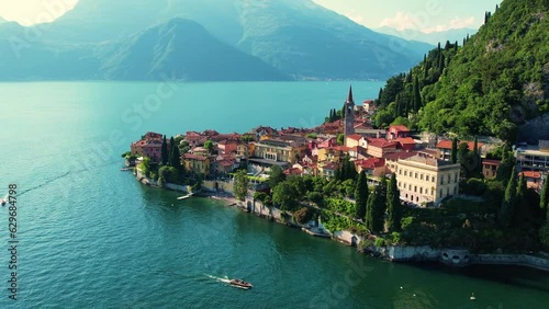 Aerial 4K footage of Varenna, Como Lake. Drone panoramic view of town surrounded by mountains, blue sky and turquoise water and located in Como Lake, Lombardy, Italy