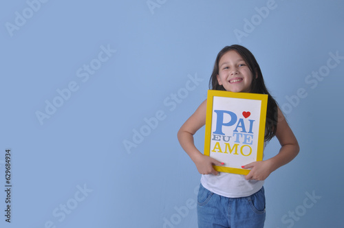 menina pré adolescente criança segurando placa de feliz dia dos pais com mensagem pai eu te amo, celebração dia dos pais  photo
