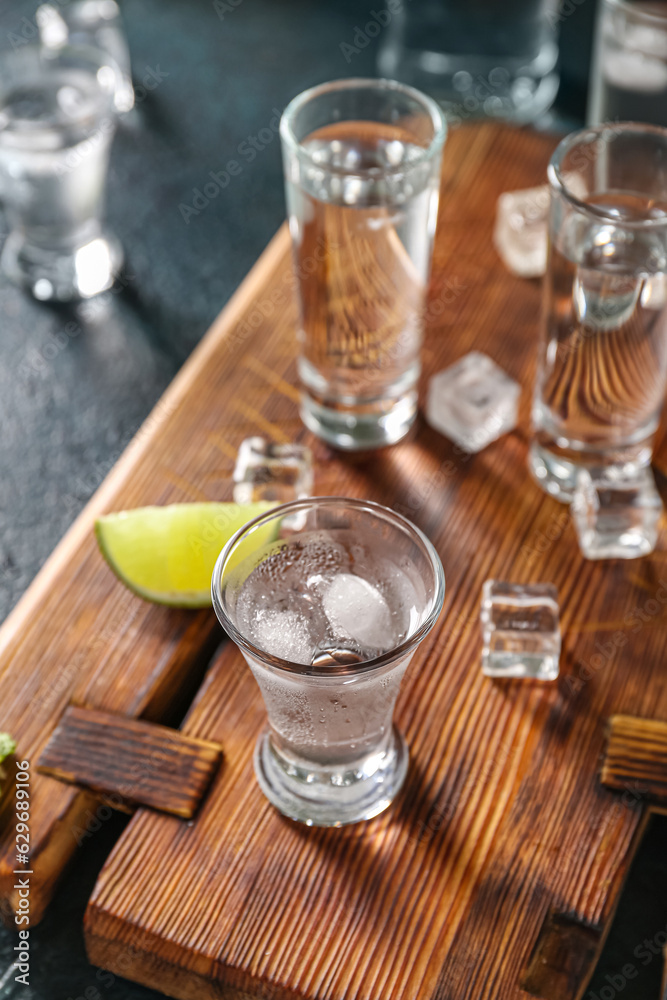 Glasses of cold vodka on black background
