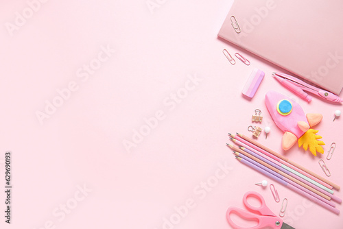 Rocket made of plasticine with different stationery on pink background © Pixel-Shot