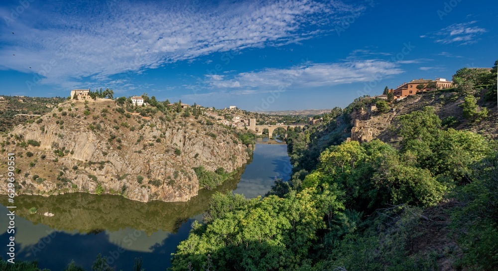 Fototapeta premium toledo, spain, tajo, river, bridge, summer, heat, sunny, sky, blue, architecture, city, town, landscape, building, village, europe, view, travel, house, italy, ancient, old, medieval, tourism, panoram