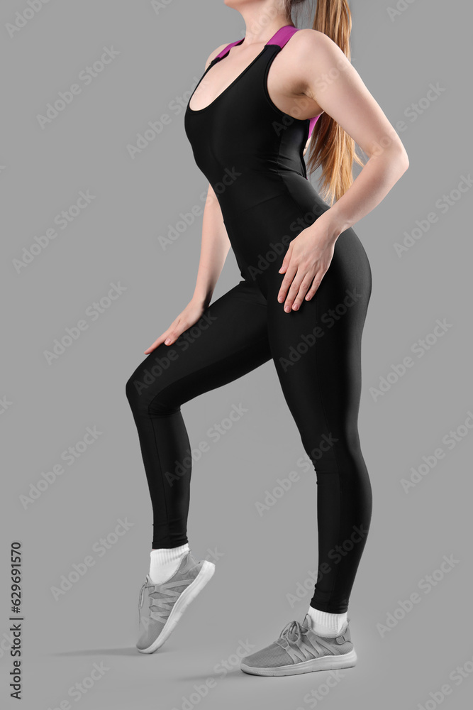 Young woman in sportswear on grey background Young woman in sportswear on grey background