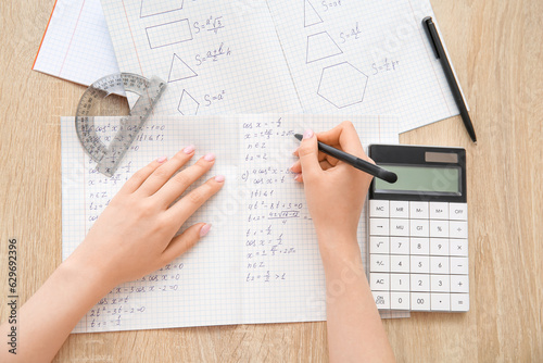 Εκτύπωση καμβά Woman writing math formulas in copybook on wooden table