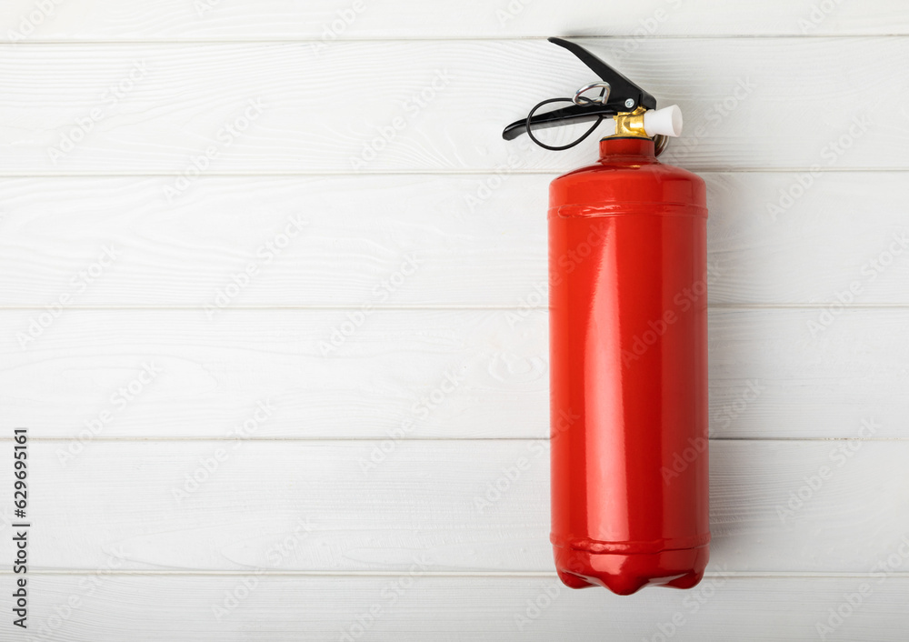 Fototapeta premium Fire extinguisher on a white texture background. Fire protection, home fire extinguisher. home security concept. Place for text. Copy space.banner