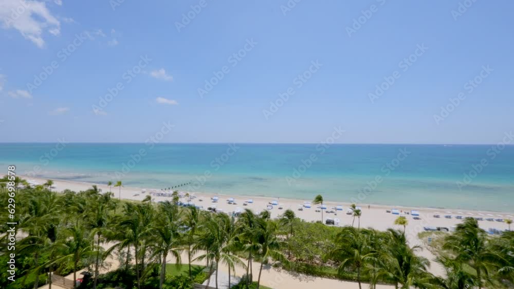 Paradise sunny beach with lots of tropical palm trees and turquoise waters of Atlantic ocean. Incredible view of Sunny Isles Beach resort from high-rise building terrace Paradise sunny beach with lots of tropical palm trees and turquoise waters of Atlantic ocean. Incredible view of Sunny Isles Beach resort from high-rise building terrace