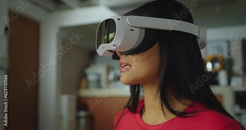 Beautiful asian woman wearing VR in living room at home. She using VR to talking with friend in Metaverse world. the concept of metaverse, versual reality, future, technology, and internet of things. photo