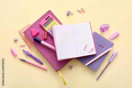 Different school stationery and notebooks on beige background