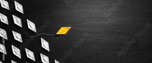 Yellow Paper Boat Leaving Mainstream And Changing Direction On Modern Black Wooden Table  - Entrepreneur Concept	
