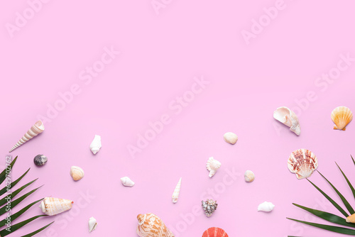 Composition with different seashells and palm leaves on pink background