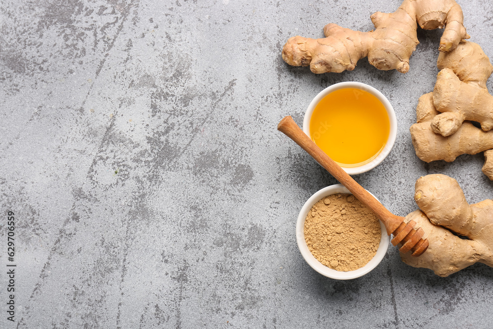 Fototapeta premium Fresh ginger roots and bowl with dried powder on blue background