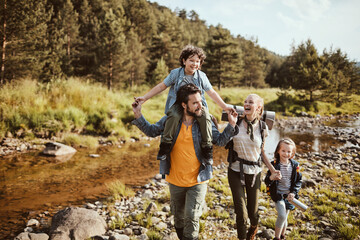 Young family hiking in the forest next to a creek
