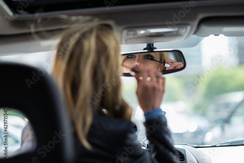 Woman applying make-up in car