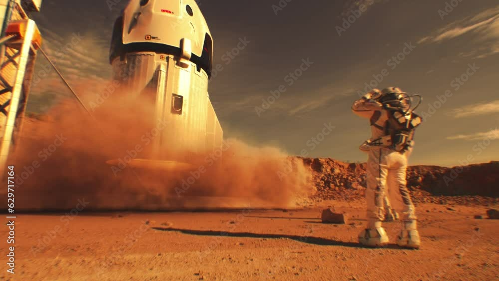 Two astronauts in spacesuits stand, watch spacecraft landing on Mars surface. Manned space mission on red planet. Technological advance of the future. Futuristic colonization and exploration concept.