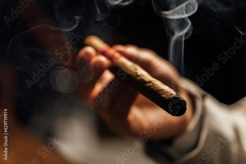 Man smoking cigar with smoke on a black background