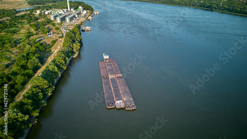 Aerial view of tugboat pushing barges up a river