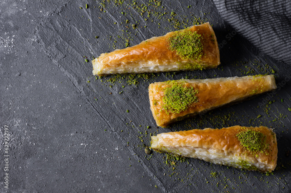 Traditional turkish dessert carrrot slice antep baklava with pistachio on rustic background. Desserts concept