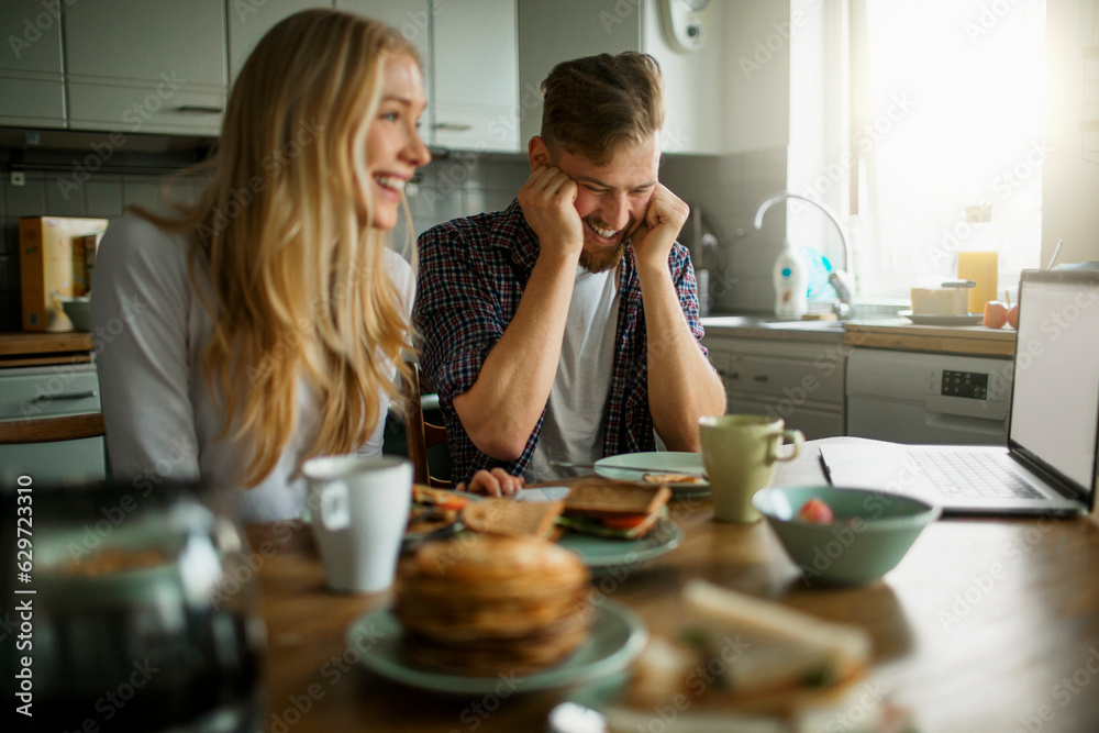 Young couple having breakfast together in the morning in the kitchen of their house Young couple having breakfast together in the morning in the kitchen of their house