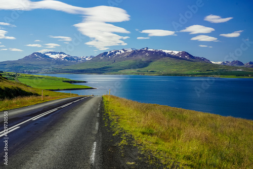 Fjords beautiful road through snow peak mountains and green flat valleys in Iceland