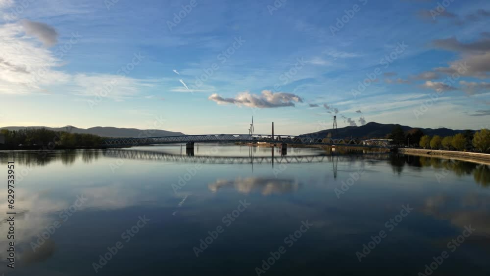 Panoramic view of a metal bridge over the Rhone river at sunrise in the south of France in the village of Le Pouzin (Ardeche) Panoramic view of a metal bridge over the Rhone river at sunrise in the south of France in the village of Le Pouzin (Ardeche)