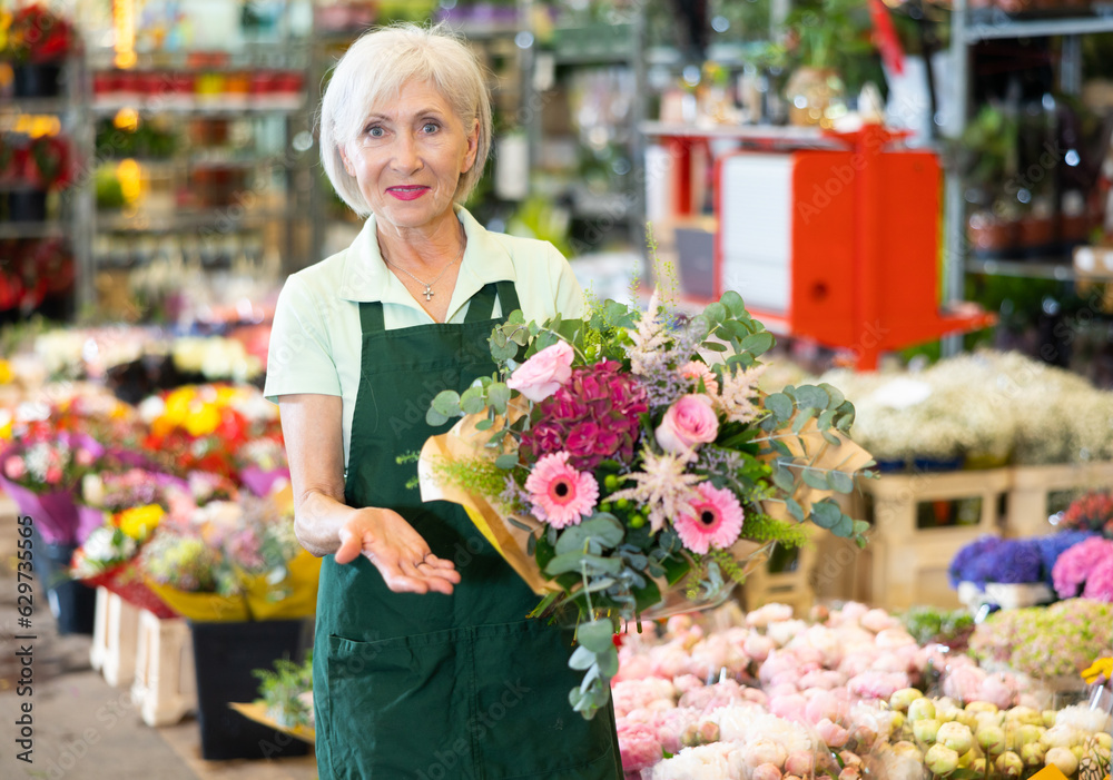 Portrait of happy owner of flower market with a bouquet in her hands