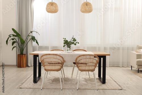 Stylish dining room with cozy furniture and plants © New Africa