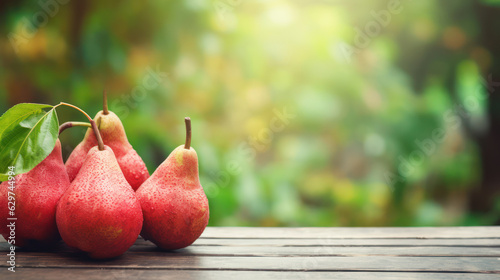 Red pears on grey wooden tabletop on blur garden background photo
