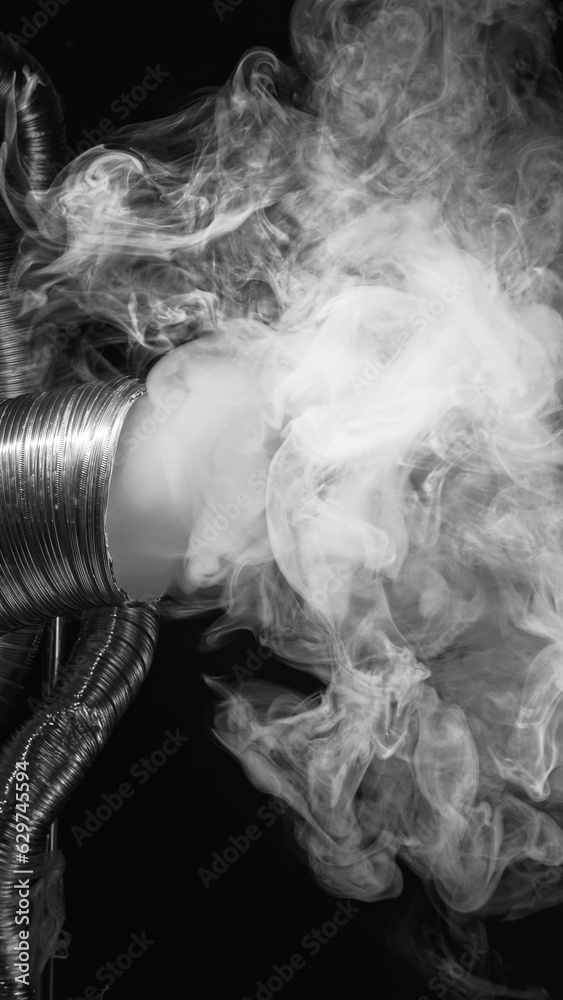 Smoke pollution. Chemical fume. Smog emission. White industrial gas flow from flexible exhaust duct pipe on dark black abstract free space background.