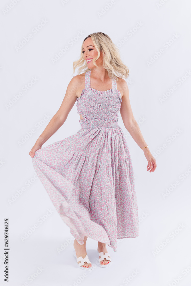 Blonde woman in purple spring dress against white background