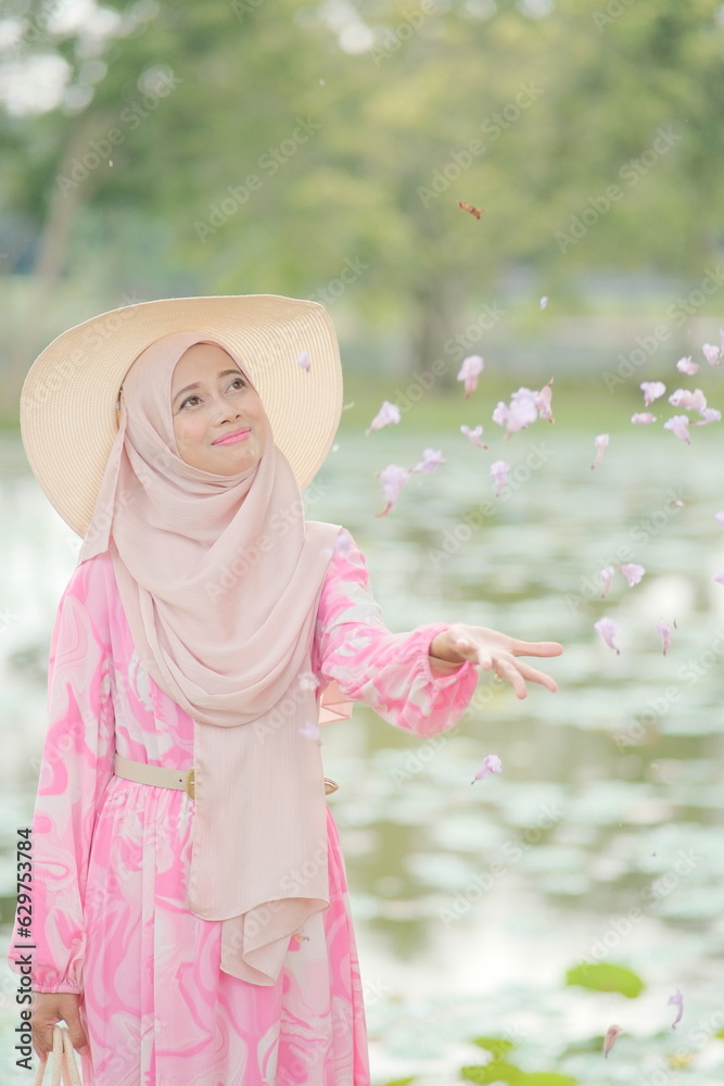 Portrait of beautiful young Muslim girl wearing Hijab and  dress in outdoor scenes during holiday. Stylish Muslim female hijab fashion lifestyle portraiture concept.

