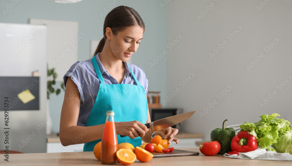 Beautiful young woman making vegetable salad in kitchen Beautiful young woman making vegetable salad in kitchen
