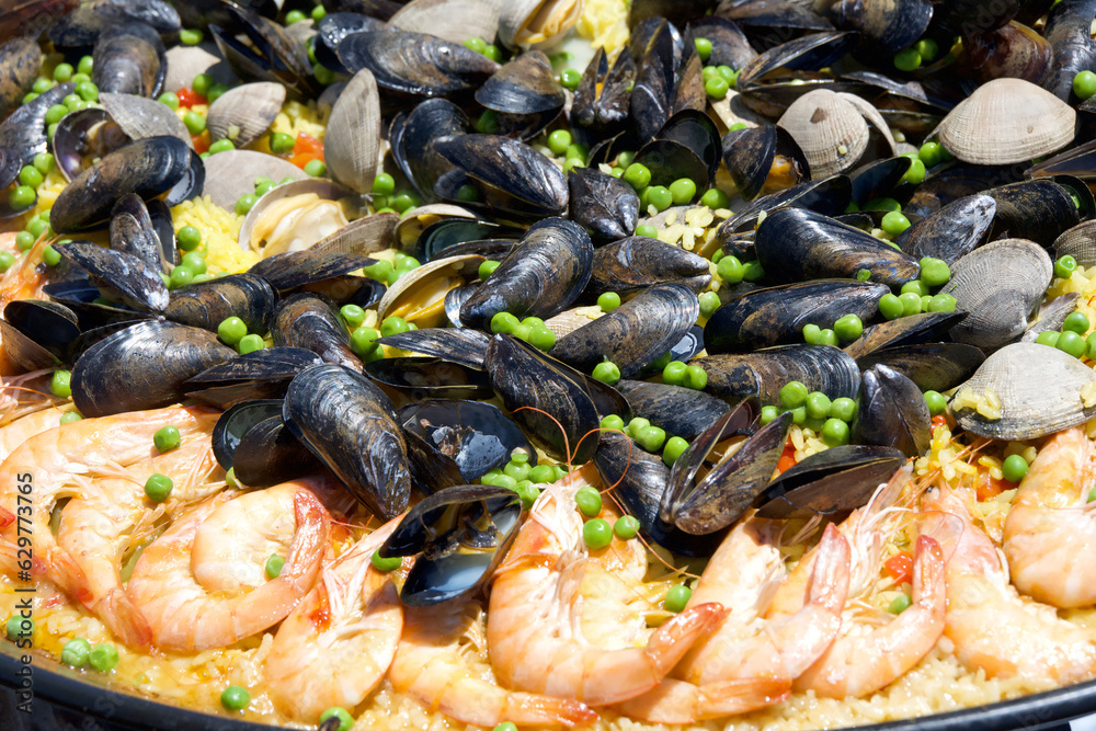 Close up on clams, muscles, shrimp rice and peas cooking in a giant outdoor wok. Close up on clams, muscles, shrimp rice and peas cooking in a giant outdoor wok.