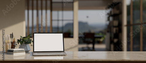A laptop mockup on a tabletop with a blurred modern office as a background.