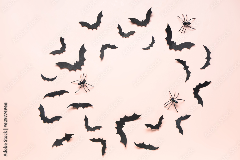 Frame made of paper bats and spiders for Halloween party on pink background