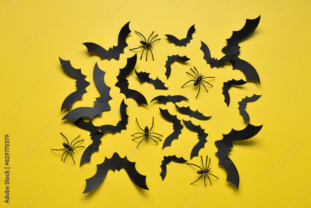 Naklejka premium Paper bats and spiders for Halloween party on yellow background