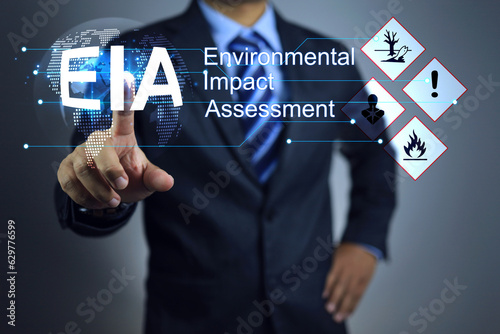 Obraz na plátne Businessman pointing to approval the EIA or environmental impact assessment, taking into account the environmental impact of every process of project from inception use