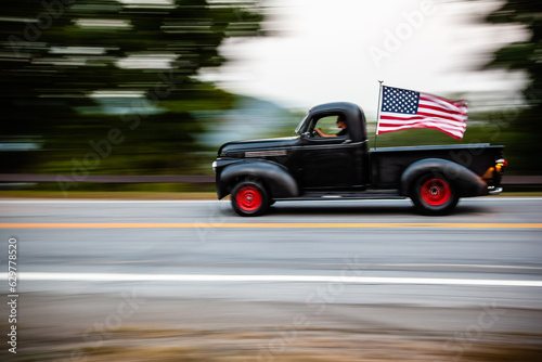 Old truck with American flag movie on highway 