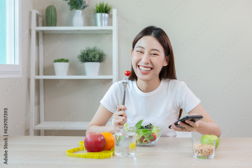 Happy females smiling eating salad vegetables fruit and using smartphone, diet day weight counting calories. eating and health care concept. Happy females smiling eating salad vegetables fruit and using smartphone, diet day weight counting calories. eating and health care concept.