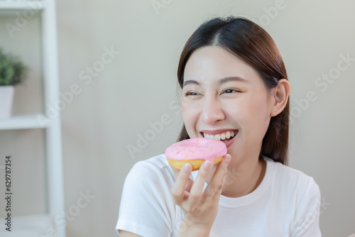 Beautiful asian female eating donut choosing healthy eat. healthy food choices. Starchy foods can make you fat. Girl keep their diet. Diet healthy food concept.