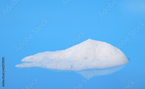 white foam from soap isolated on a blue background © VRVIRUS