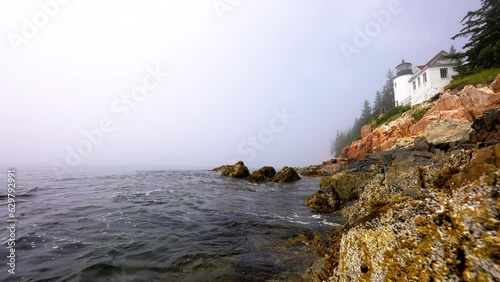 water level view of bass harbor Maine lighthouse with waves moving in and out with the tide photo
