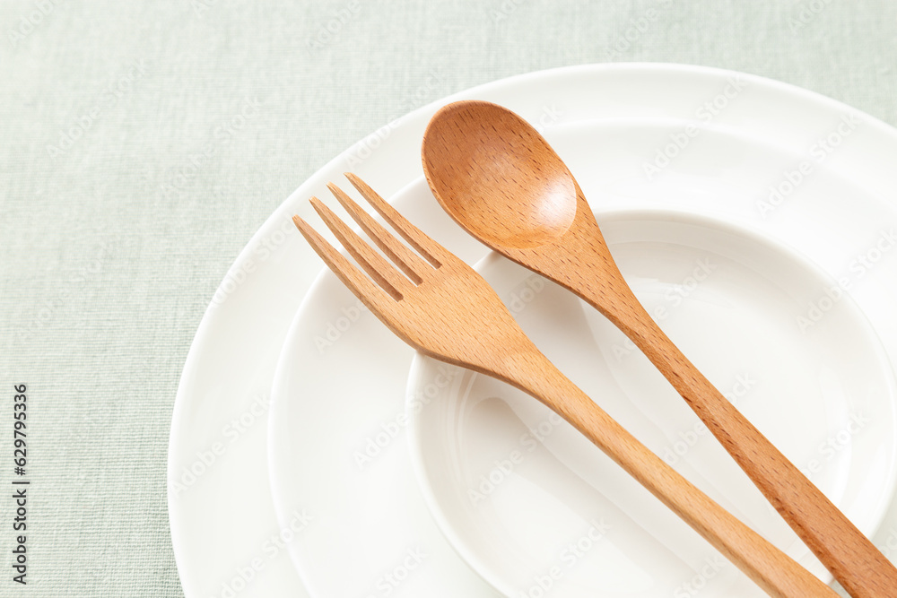 ランチョンマットに皿と木製のカトラリー。