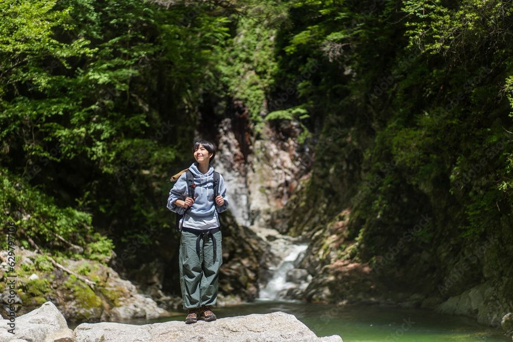 新緑の山を登山する若い日本人女性 新緑の山を登山する若い日本人女性