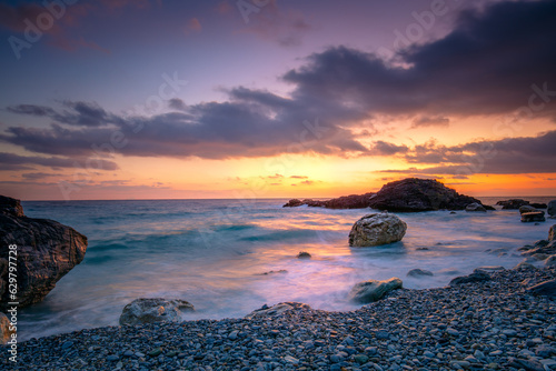 Sea Ocean.  Sunrise time at the sea.  Big roks. Wave hit the rock at beach  sea water splash up to the sky with sun. Sunset Sundown at Sea. Storm. Landscape.