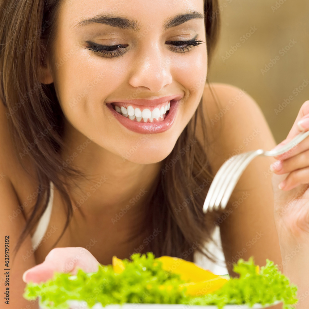 Portrait of happy smiling young woman with vegetarian vegetable salad, at home Portrait of happy smiling young woman with vegetarian vegetable salad, at home