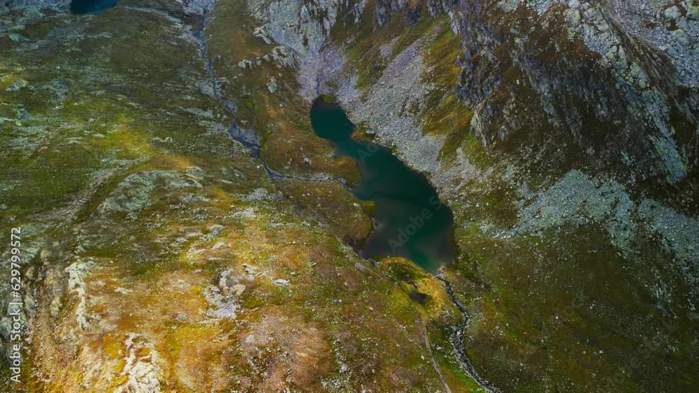 Mountain lake Naret in Switzerland nestled between mountains. Aerial drone tilt up view