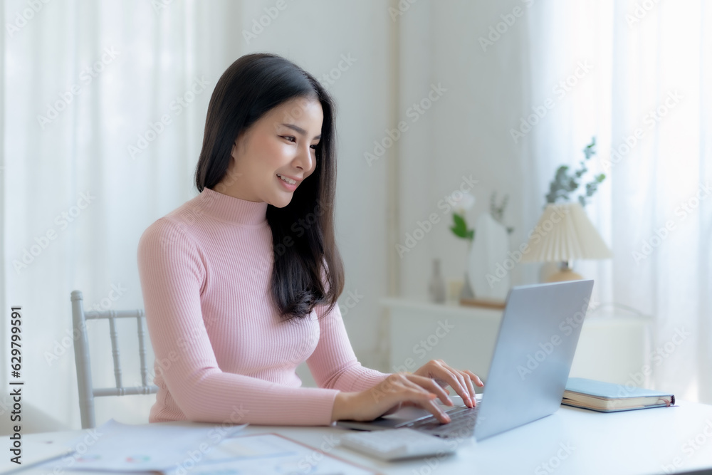 Successful Asian businesswoman smiling using laptop computer at office. Confident Asia businesswoman sitting happily in the office. Successful Asian businesswoman smiling using laptop computer at office. Confident Asia businesswoman sitting happily in the office.